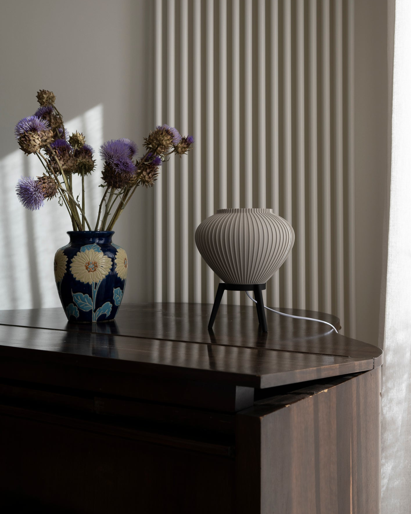 Decorative vase with flowers on a piano next to a radiator.